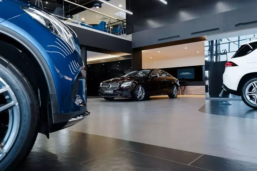 Modern and elegant car dealership with large windows showcasing a range of high-performance vehicles.